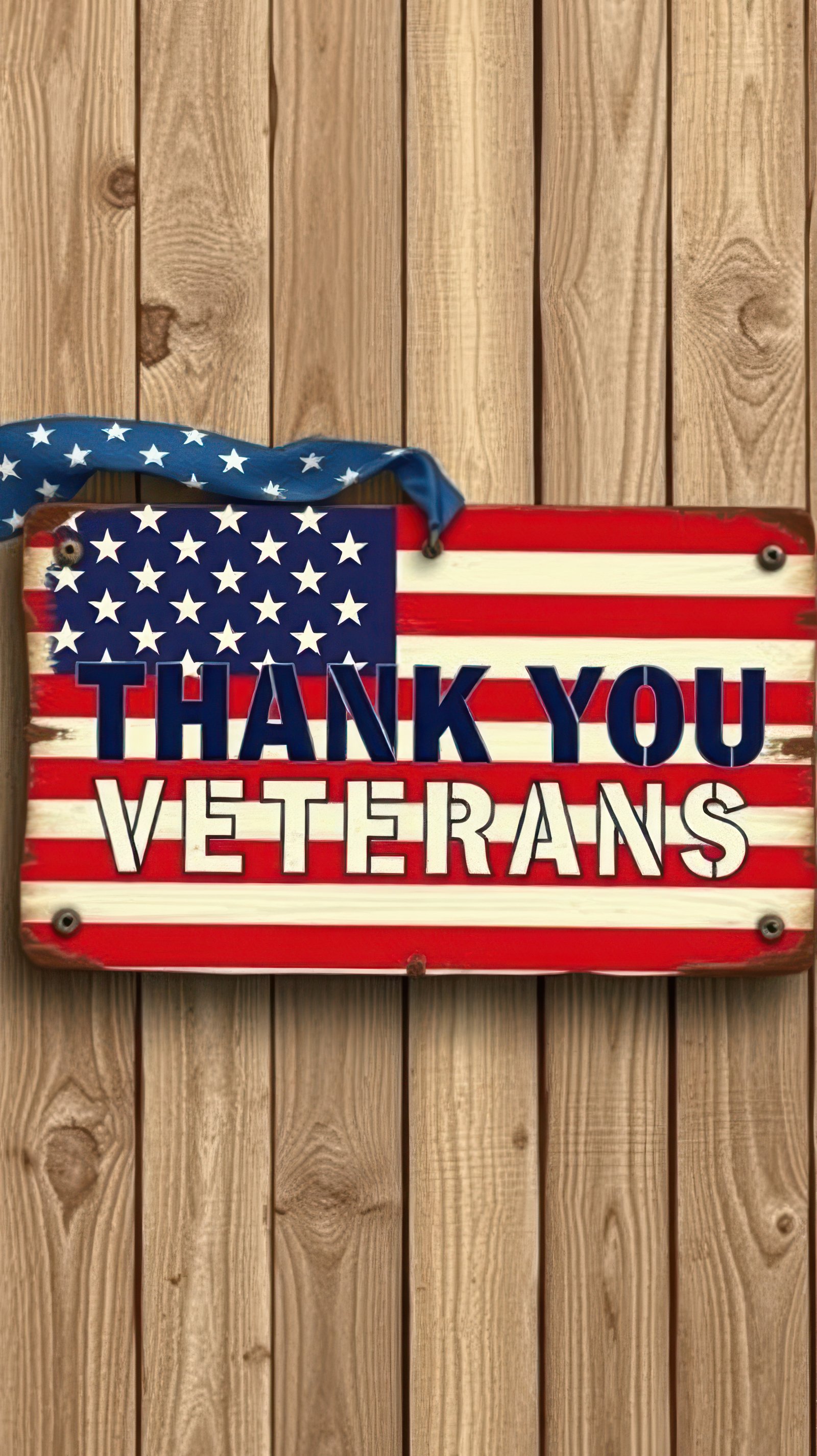 Tribute sign expressing gratitude to veterans against a wooden background with an American flag design